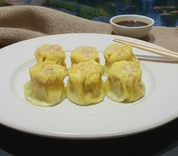 Steamed Dim Sims Plate of six steamed pork dim sims with carrot and cabbage filling, served warm and tender.
