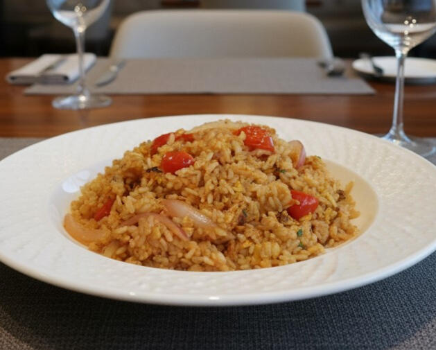 Thai Fried Rice Thai fried rice with chicken, egg, tomatoes and onions, served as a generous portion.