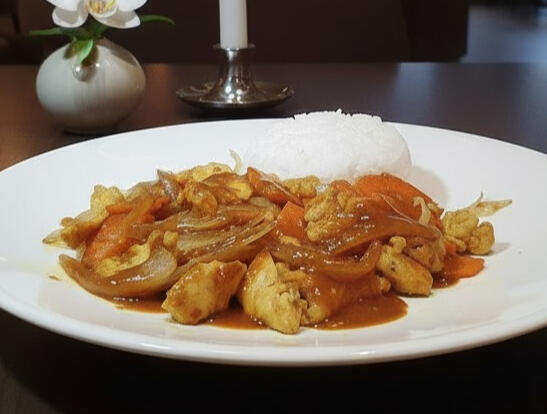 Stir-Fried Chicken Satay Stir-fried chicken satay with steamed rice, featuring marinated chicken breast, carrots and onions topped with rich satay sauce.